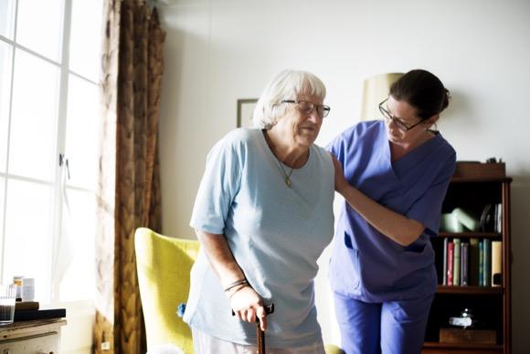 Home care in Woking. Carer assisting elderly woman in her home.
